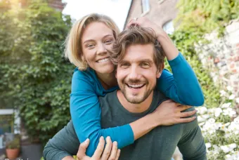 Une femme embrasse un homme et les deux rient